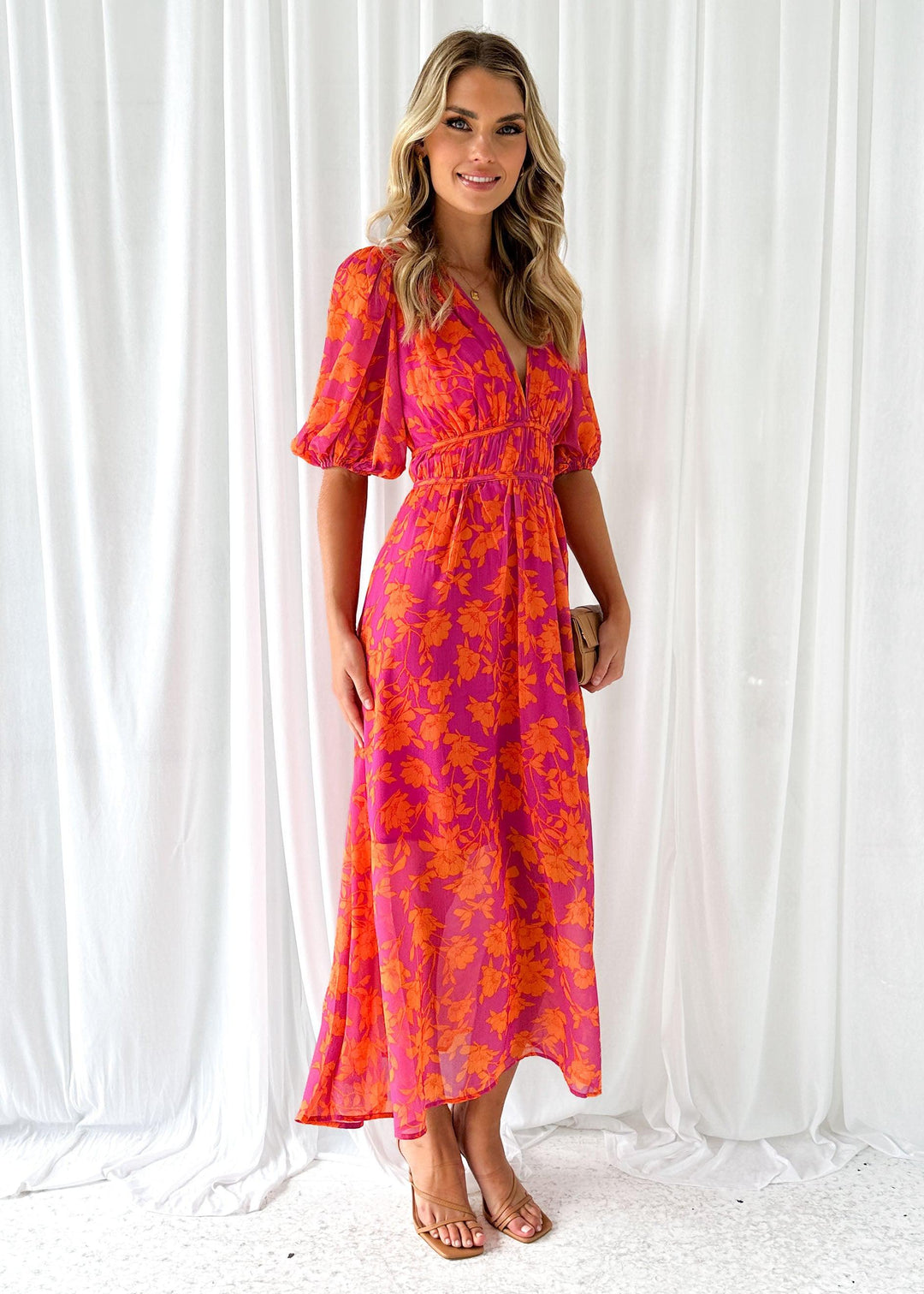 Vestito svasato lungo donna rosa arancione con profondo scollo a V. Abito estivo perfetto per un look sofisticato.