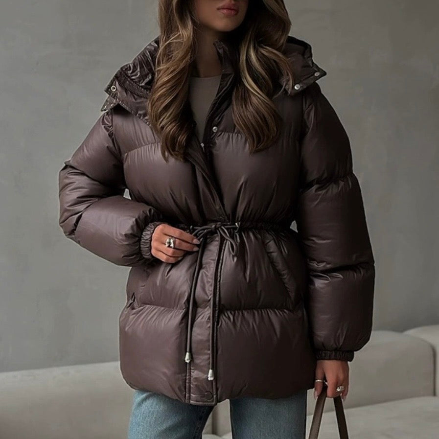 Elegante giacca invernale donna con collo alto e vita regolabile. Capospalla chic per moda invernale.