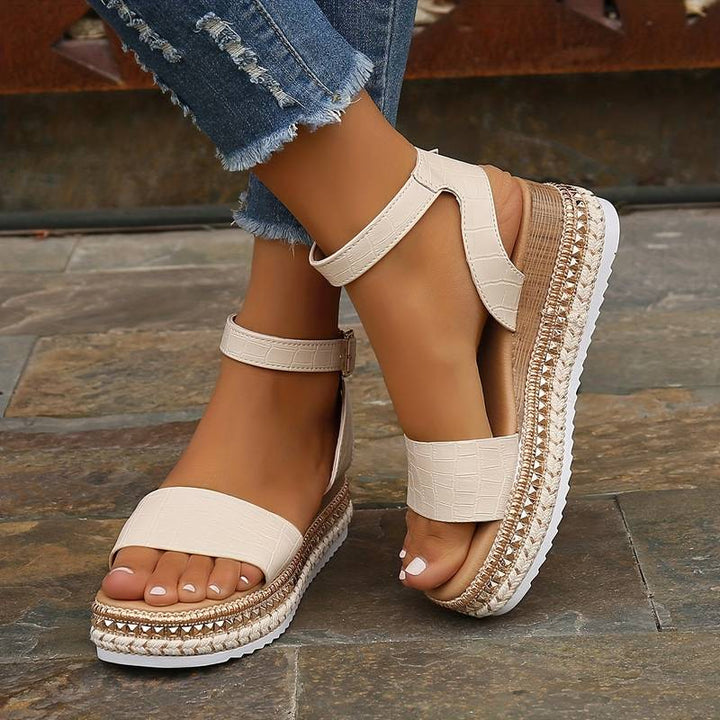 Primo piano su sandali platform donna estivi, cinturino alla caviglia, suola comoda, perfetti per la moda mare.