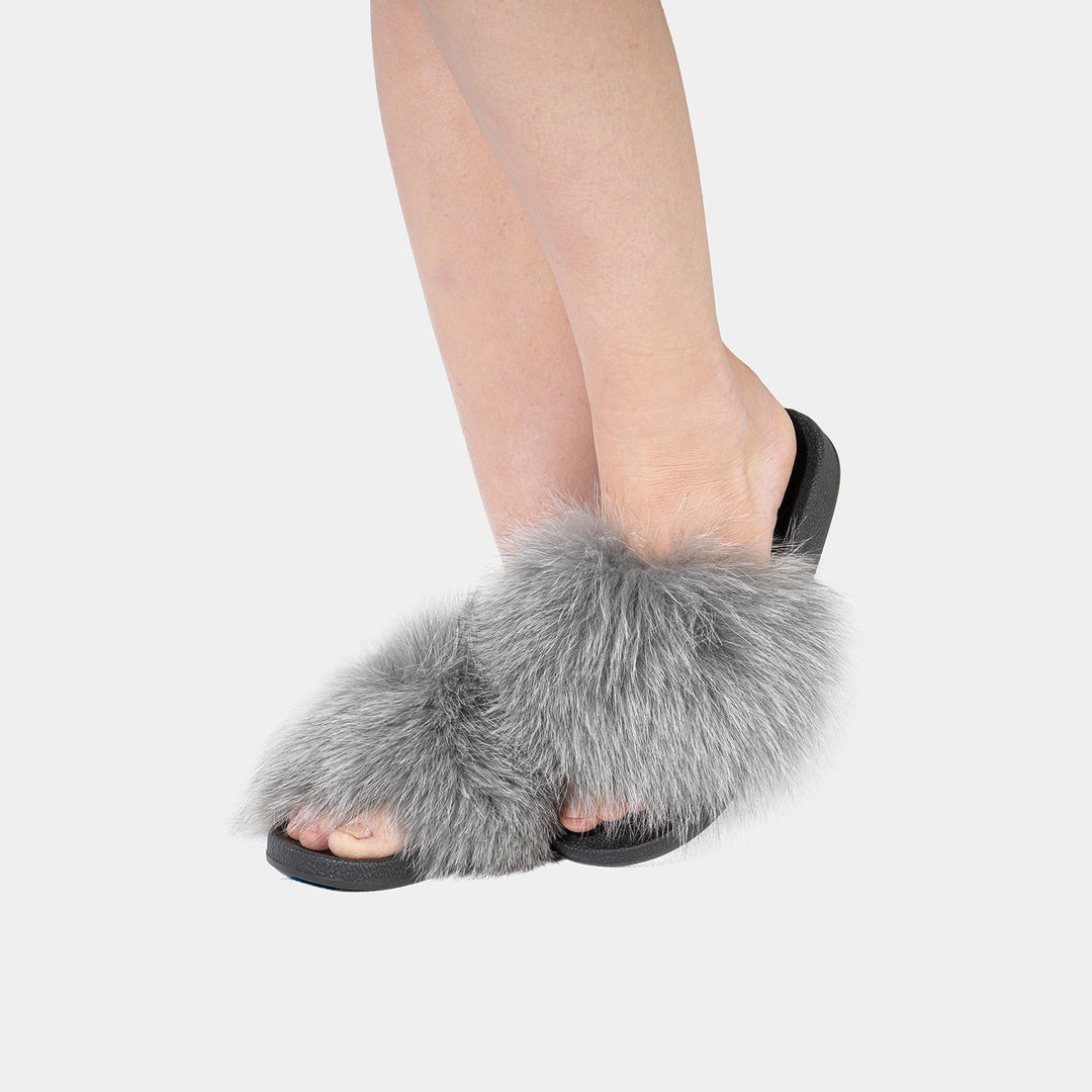 Morbide pantofole da donna in vera pelliccia di volpe grigia. Dettaglio suola in gomma per comfort e sicurezza.