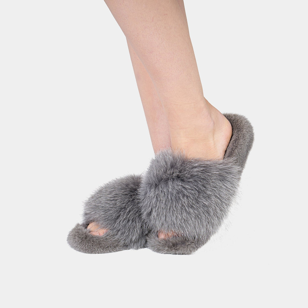 Morbide pantofole da donna grigie in pelliccia, lussuose e calde per il relax a casa in inverno.