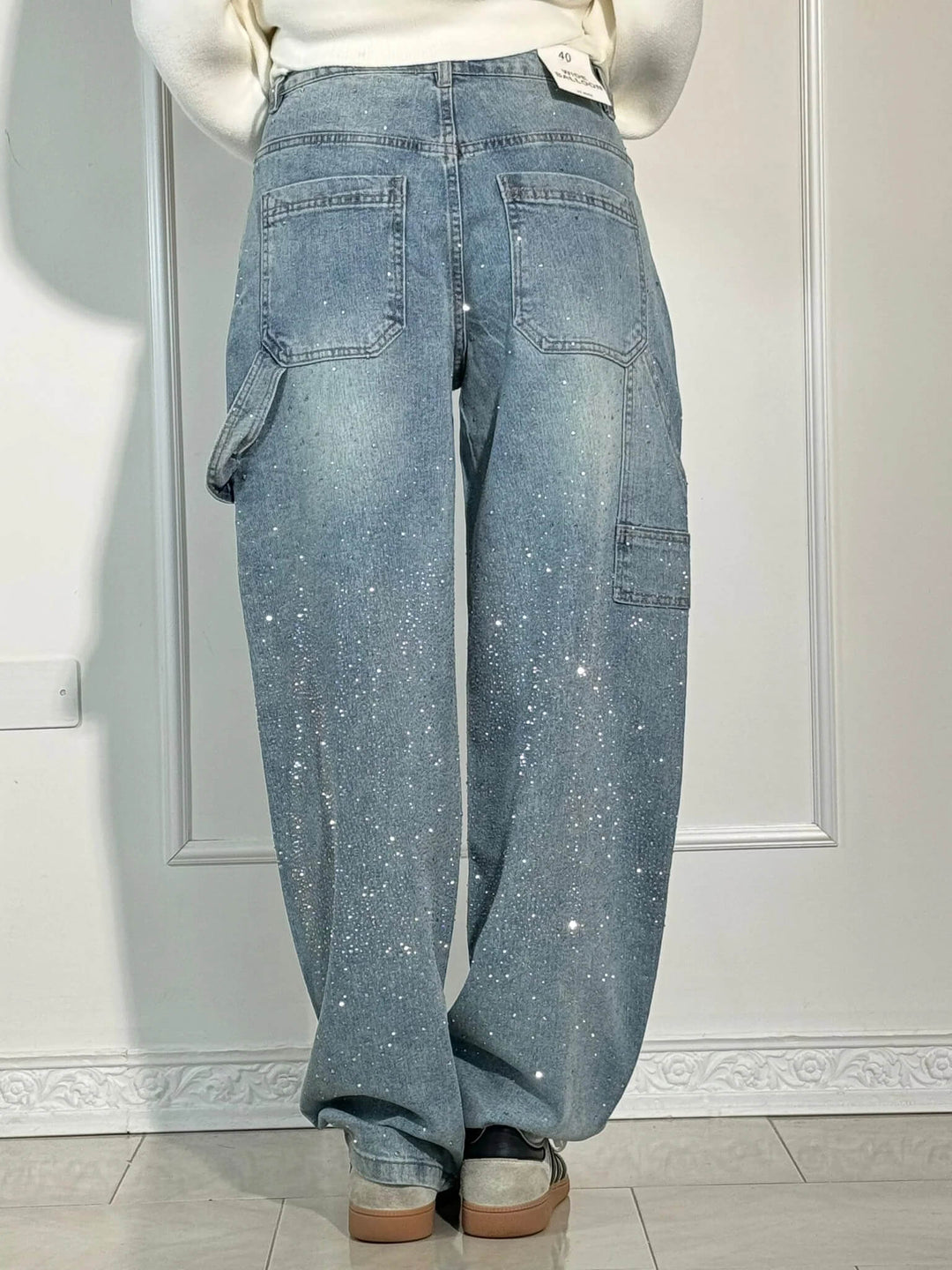 Dettaglio dei jeans balloon con ricami luminosi, tessuti di qualità per la donna.