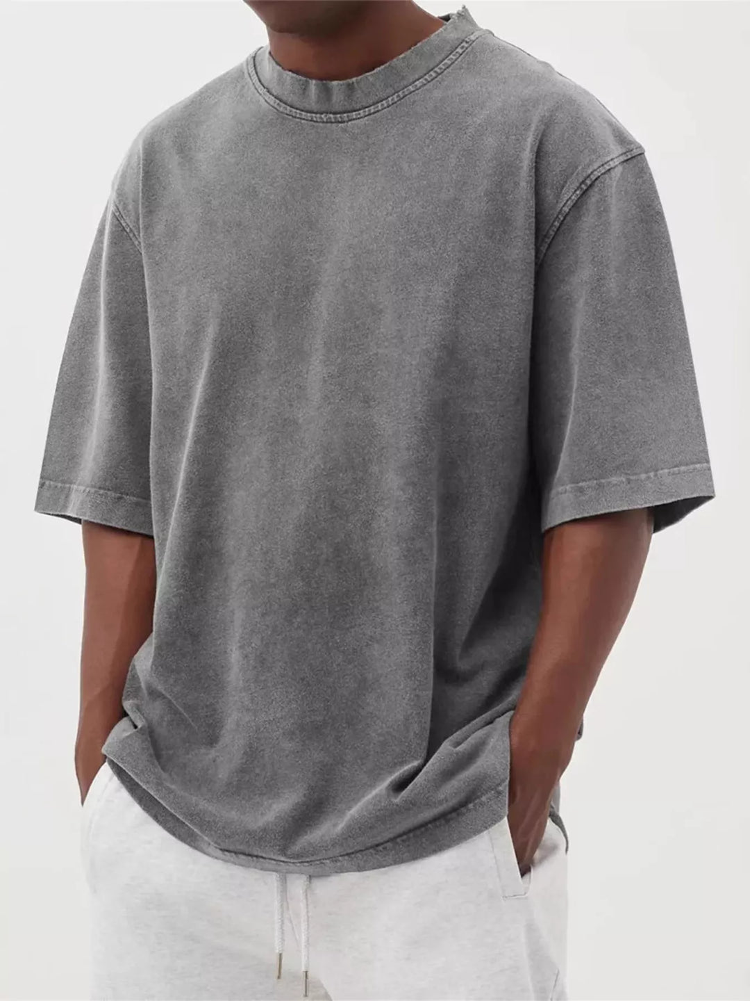Uomo che indossa una maglietta oversize a maniche corte, effetto lavato, per un look alla moda.