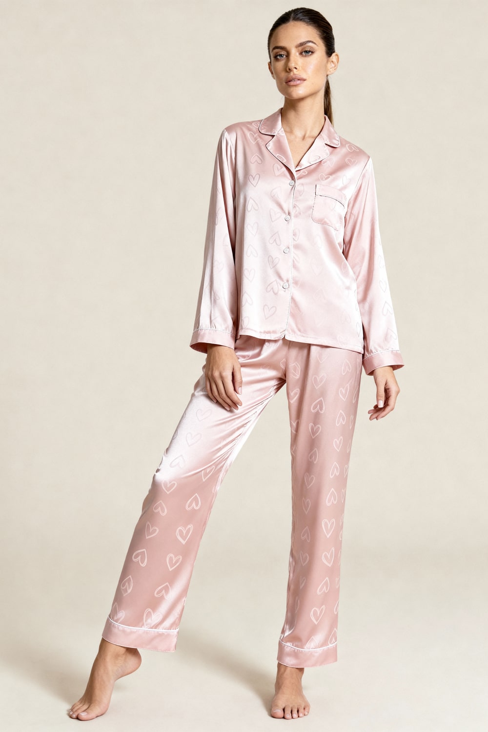Pigiama donna elegante in satin jacquard rosa con motivo a cuori. Completo loungewear chic per relax e comfort.