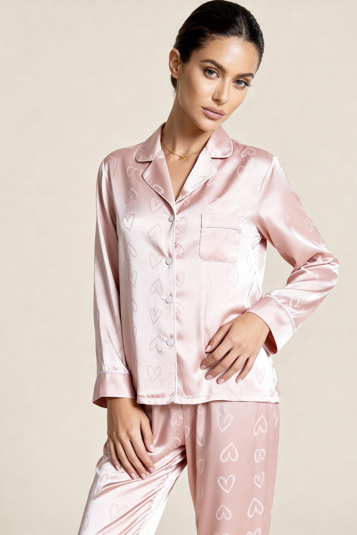 Pigiama donna in satin jacquard rosa. Design elegante con cuori, perfetto per serate rilassanti e glamour.