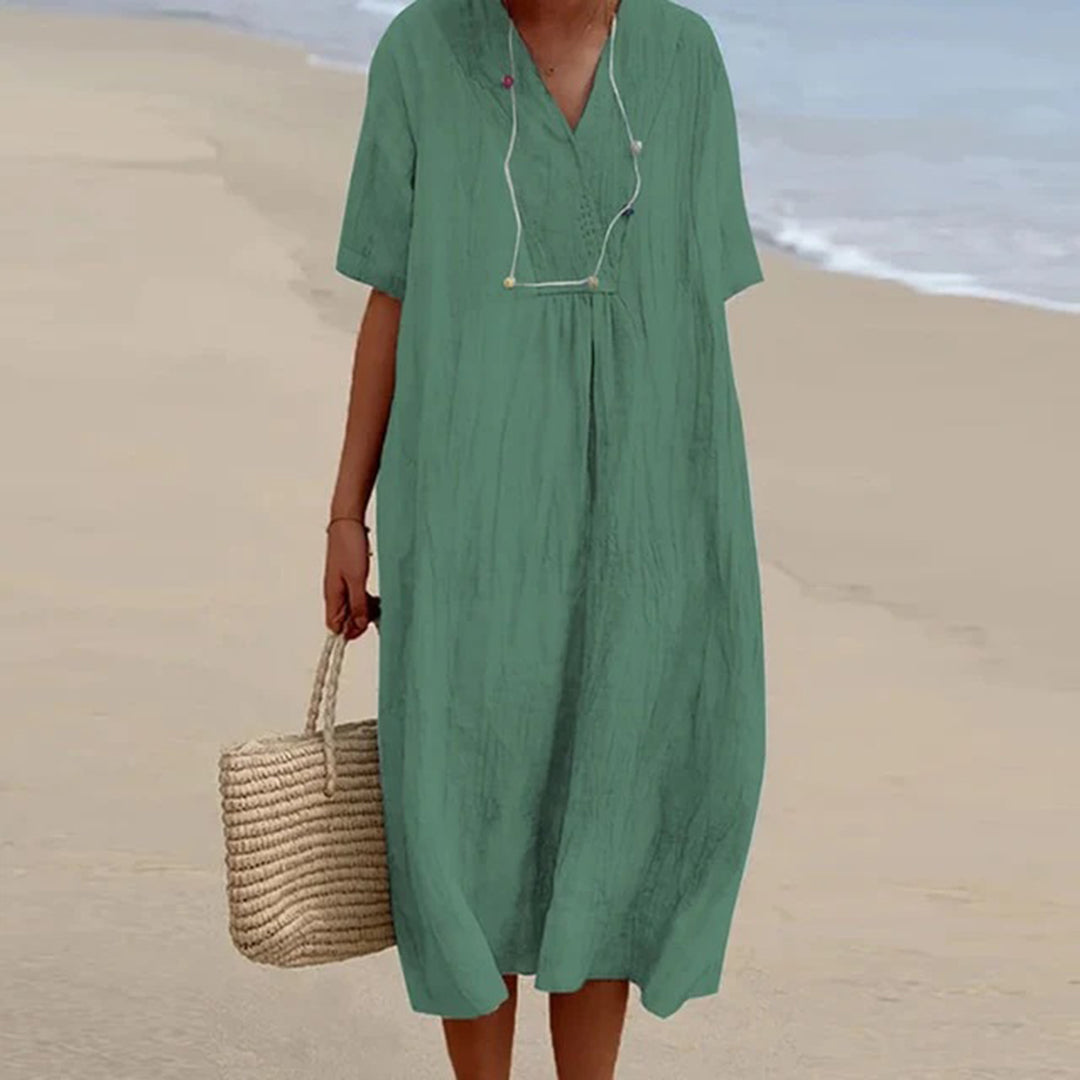 Donna che indossa abito midi rilassato, elegante per vacanze. Vestito estivo versatile, ideale per spiaggia.