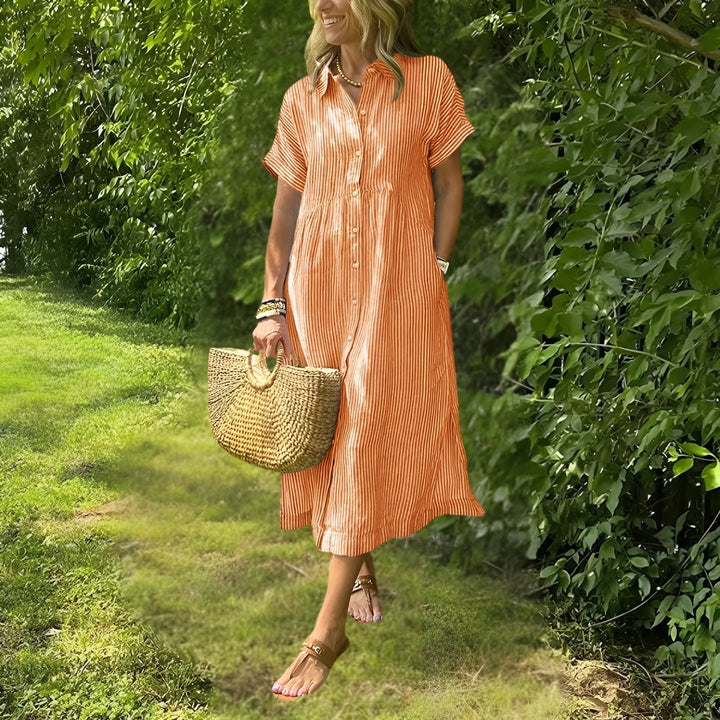Modella indossa abito midi a righe fluide, stile casual elegante, un must-have per la moda donna estiva.