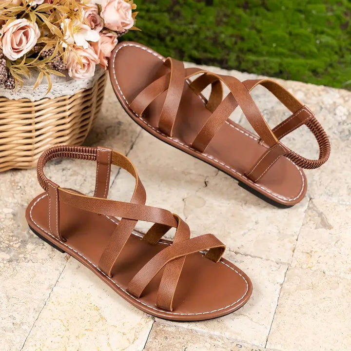 Sandali donna con fasce incrociate, modello piatto, comodi e perfetti per l'estate e il passeggio.