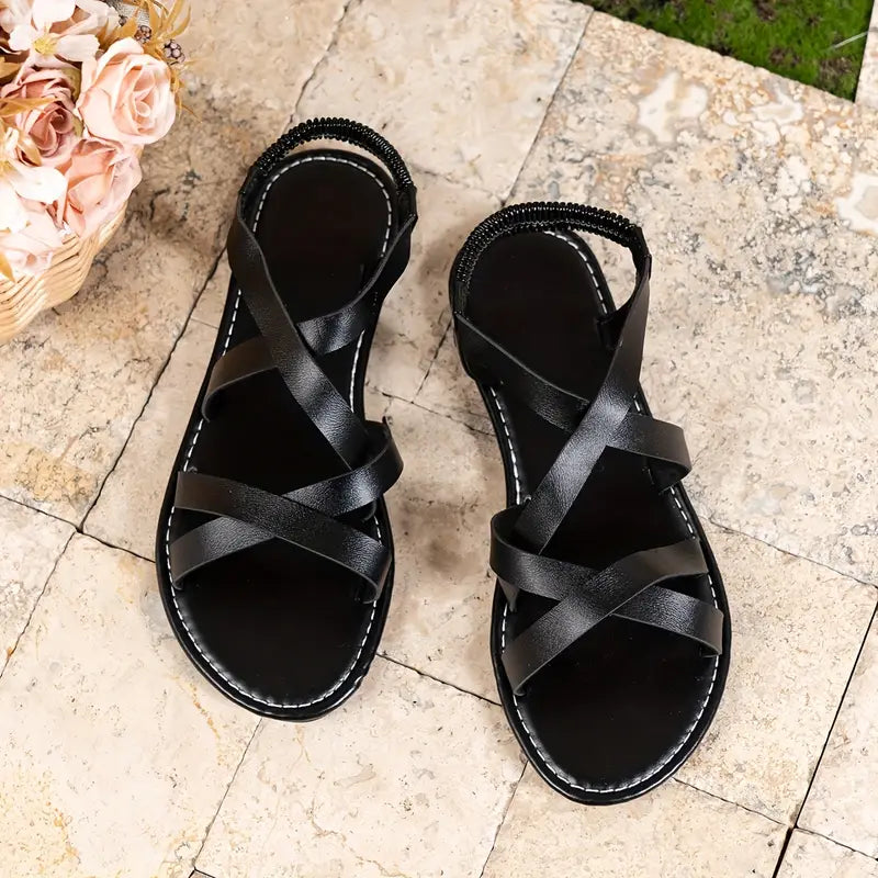 Moda estiva donna: sandali piatti con fasce incrociate, ideali per un look casual e confortevole.