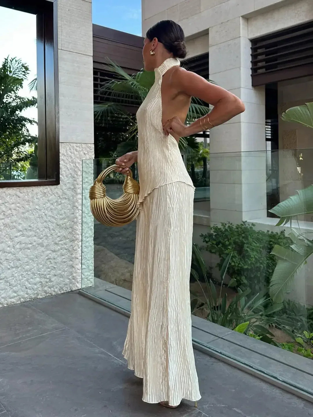 Outfit da donna due pezzi plissettato elegante, con scollo halter e pantaloni ampi, perfetto per feste.