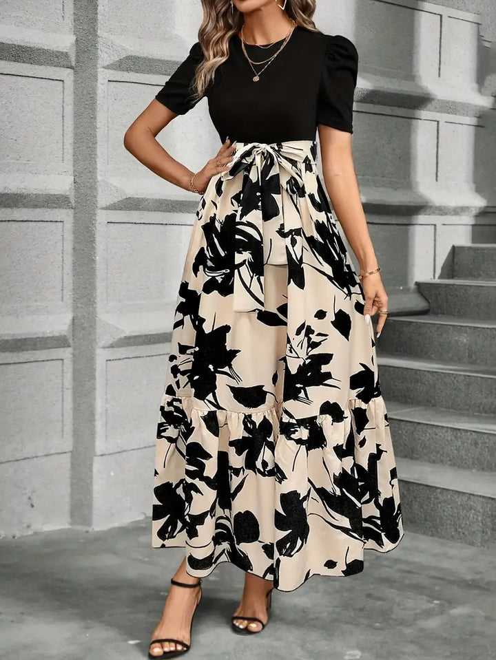 Abito lungo nero elegante da donna con fiocco in vita, un capo di moda femminile per feste e cene importanti.