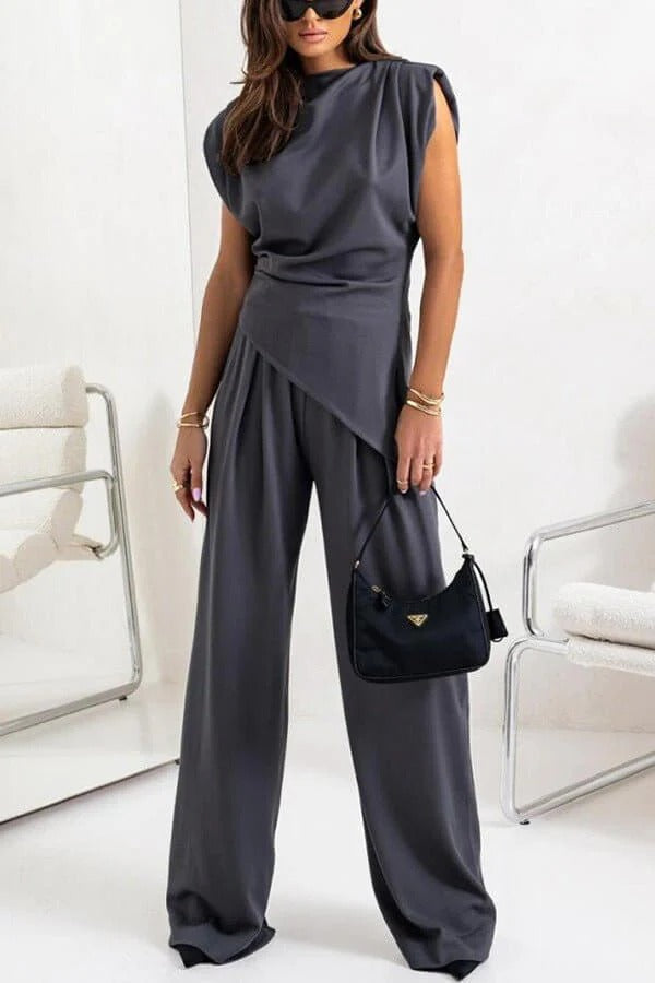 Completo drappeggiato due pezzi bianco, pantaloni larghi. Outfit moderno donna per eleganza versatile.