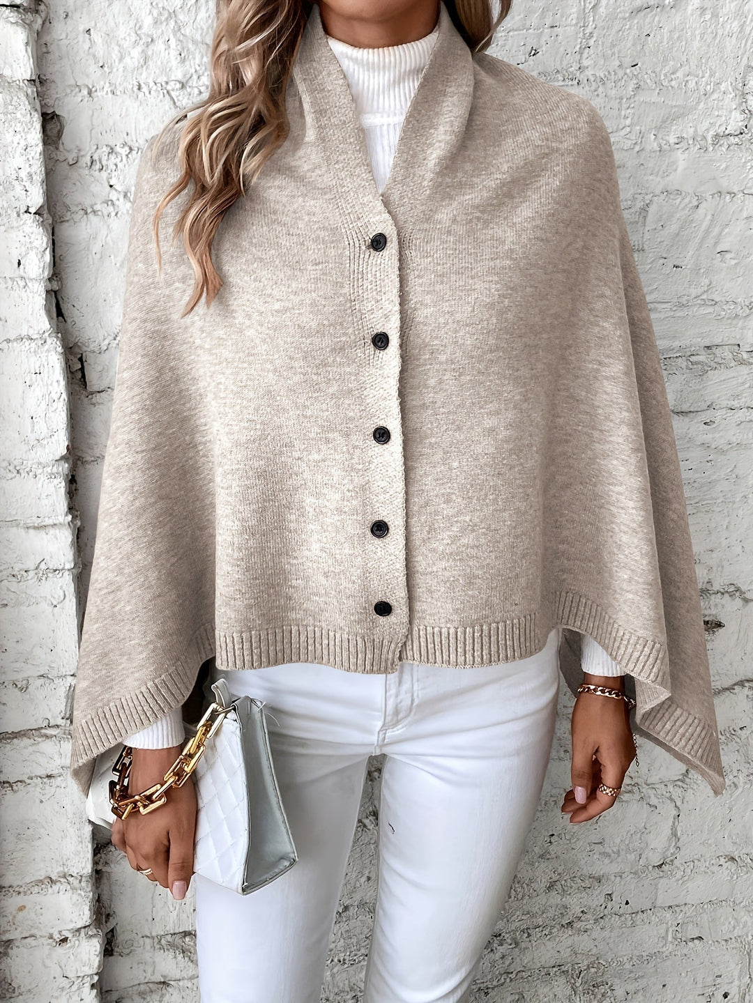 Dettaglio bottoni e tessuto del poncho donna elegante. Coprispalle caldo e versatile, perfetto per l'autunno.