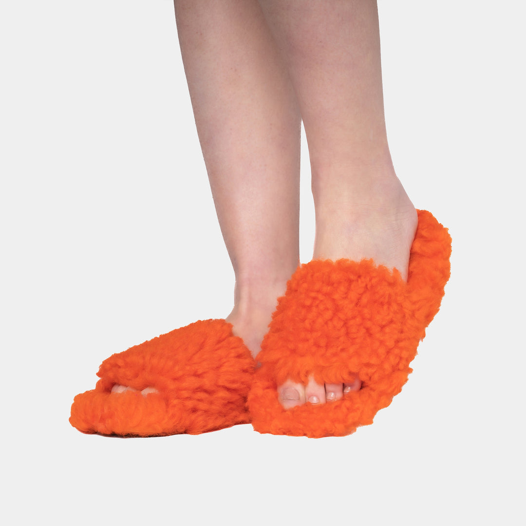 Morbide e calde pantofole da donna arancioni in montone, perfette per serate di relax invernali a casa.