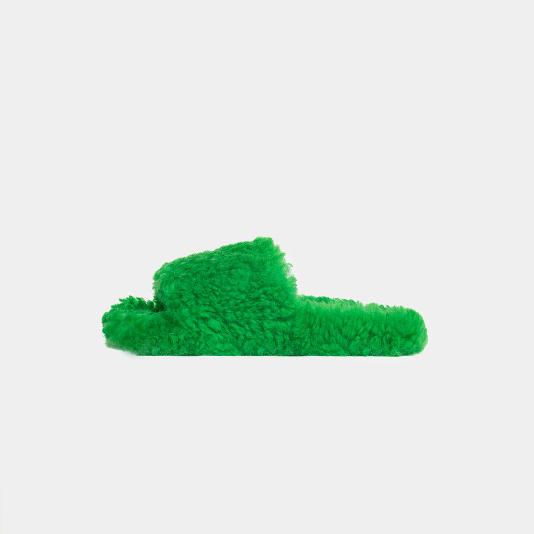 Eleganti pantofole verdi in montone da donna con comoda fascia, ideali per comfort e calore domestico.
