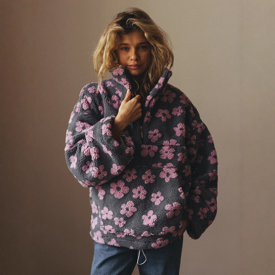 Donna che indossa maglione oversize effetto teddy, stampa floreale, per un look autunnale caldo.