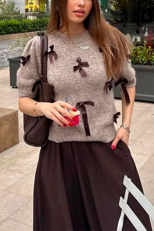 Maglione da donna con fiocchi sulle maniche, stile chic e romantico. Abbigliamento autunno/inverno alla moda.