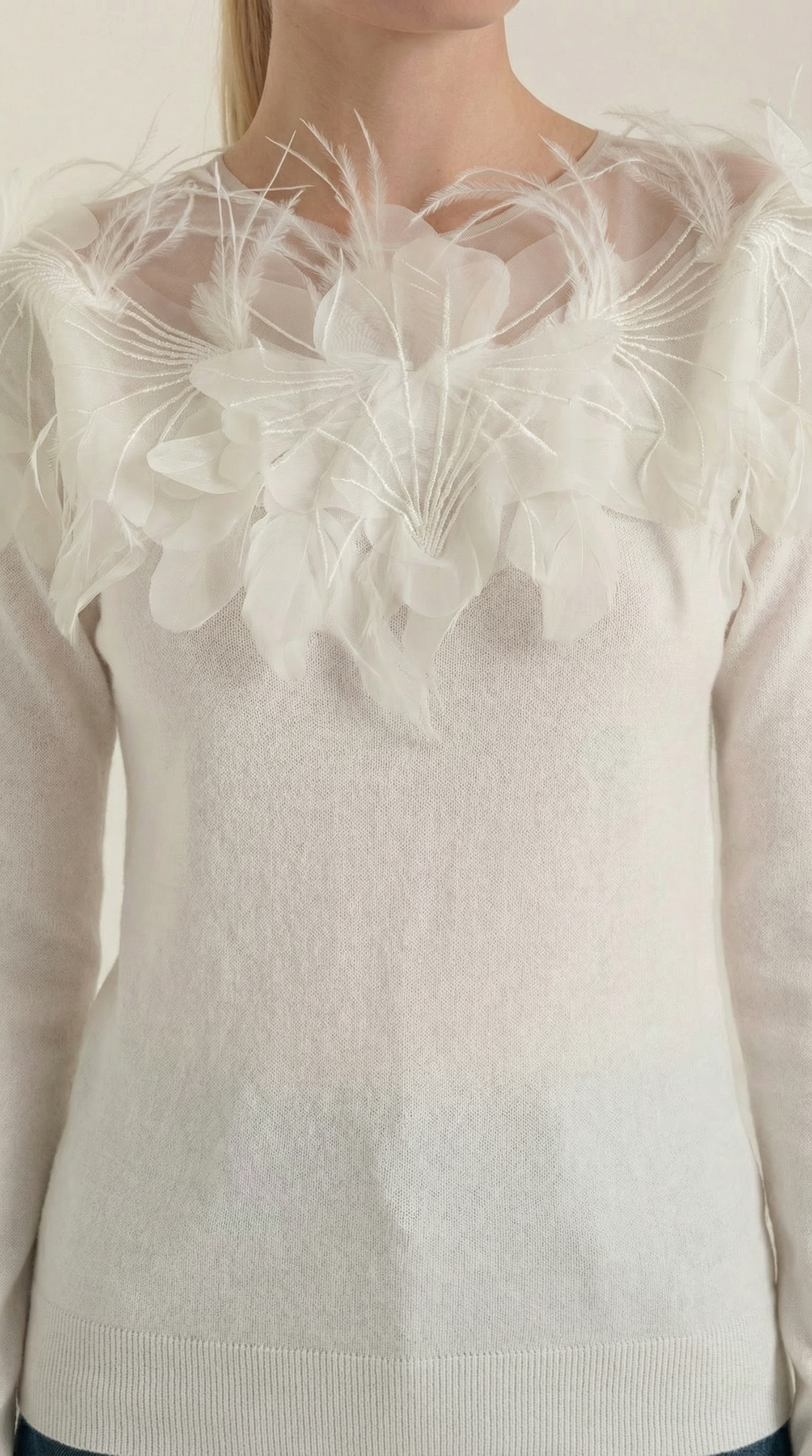 Modella indossa maglione donna elegante girocollo, con piume, ideale per abbigliamento casual chic autunno inverno.
