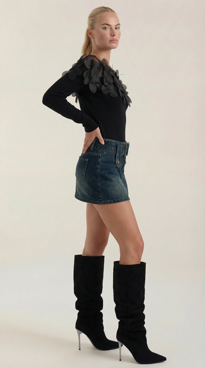 Manica di maglione donna nero con piume decorative nere sul polsino, dettaglio elegante per top invernale.
