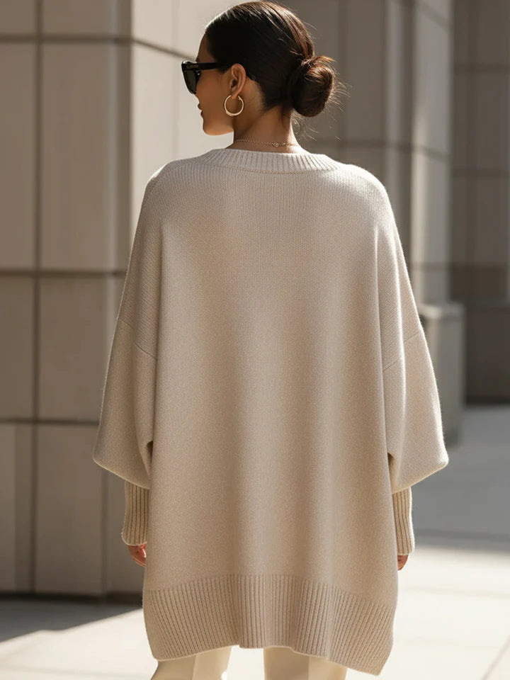 Moda donna autunno: maglione stile poncho oversize, orlo asimmetrico. Un capo versatile per ogni occasione.