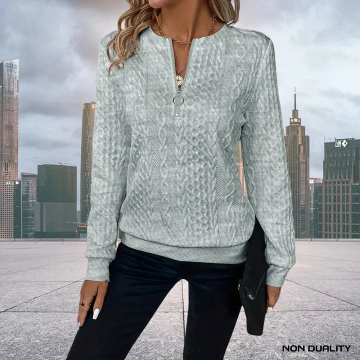 Dettaglio trama a trecce del maglione donna con mezza zip. Pullover elegante e caldo, perfetto per l'inverno.