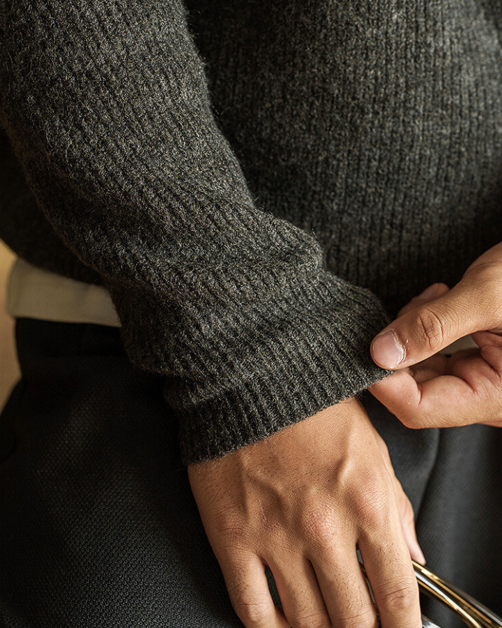 Uomo indossa maglione polo a coste grigio scuro. Vestibilità comoda, stile elegante per abbigliamento autunnale.