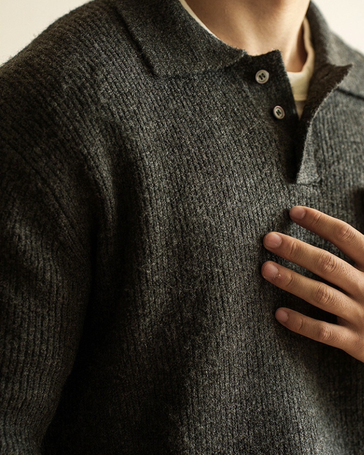 Dettaglio tessuto a coste del maglione polo uomo grigio scuro. Morbido e caldo, comfort autunno inverno.