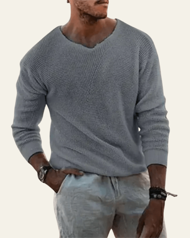 Primo piano del maglione uomo: dettaglio scollo a V e raffinata trama waffle. Maglieria di qualità, stile senza tempo.