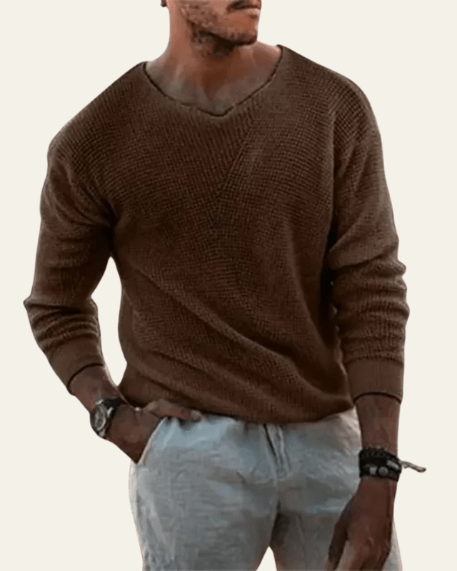 Modello indossa maglione uomo a scollo a V, trama waffle. Outfit autunnale casual ma elegante. Abbigliamento versatile.