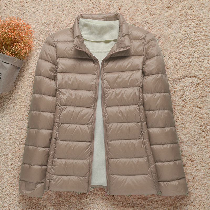 Giacca trapuntata ultraleggera da donna appesa, mostra design elegante e colori disponibili.
