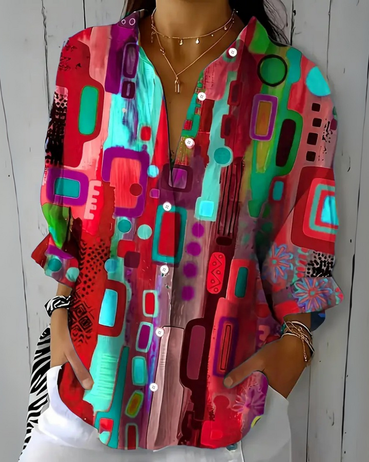 Top donna con stampa artistica multicolor su maniche lunghe. Blusa vivace che aggiunge un tocco di colore al look.