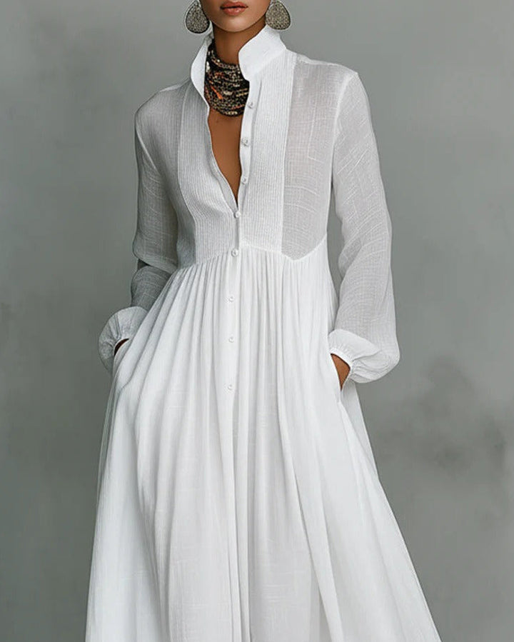 Maxi vestito donna bianco a maniche lunghe con dettagli bottoni frontali e taglio fluido, ideale per casual chic.