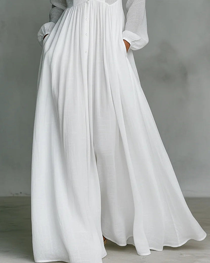 Elegante vestito donna bianco a maniche lunghe, linea fluida e bottoni frontali, un must per la moda primavera estiva.
