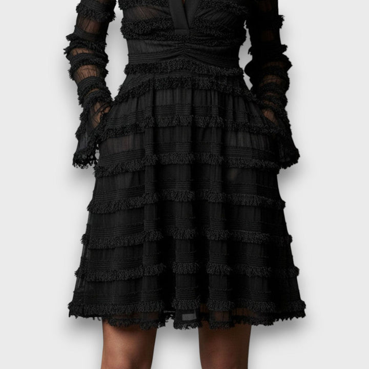 Dettaglio vestito lungo elegante nero da donna, scollo a V e maniche lunghe. Perfetto per un look autunno inverno.