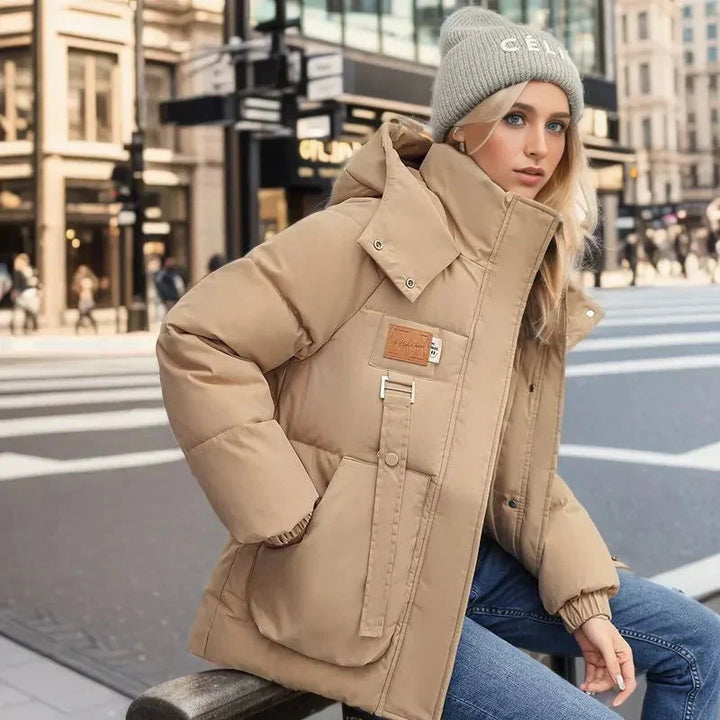 Giacca donna invernale alla moda con cappuccio e tasche. Design elegante e funzionale, ideale per un look casual e caldo.