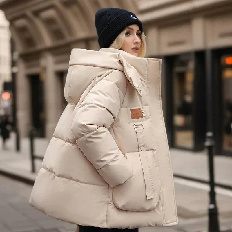 Giacca invernale donna imbottita, calda e resistente all'acqua, con cappuccio e tasche, perfetta per outdoor e stile casual.