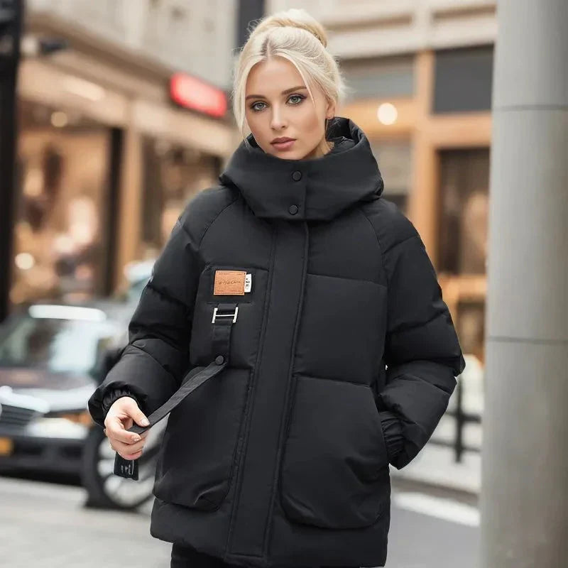 Cappotto invernale donna elegante, caldo e imbottito, con cappuccio e tasche, ideale per comfort e protezione dal freddo.