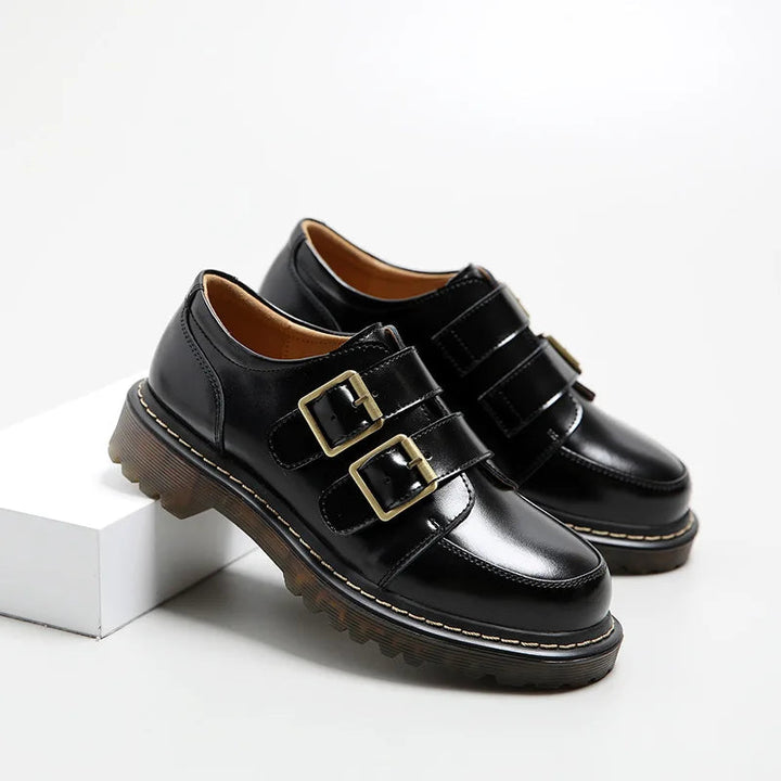 Mocassini donna eleganti con fibbia oro e raffinati dettagli brogue, perfetti per look ufficio o casual.