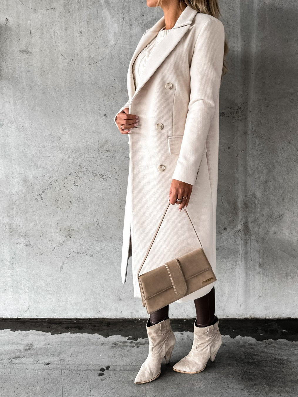 Modella indossa cappotto lungo elegante da donna, stile classico. Capospalla invernale versatile per un abbigliamento chic.