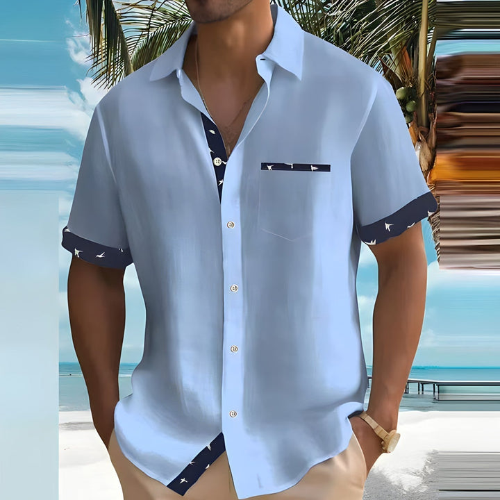 Uomo indossa camicia a maniche corte, leggera e versatile. Look estivo casual e abbigliamento maschile confortevole.