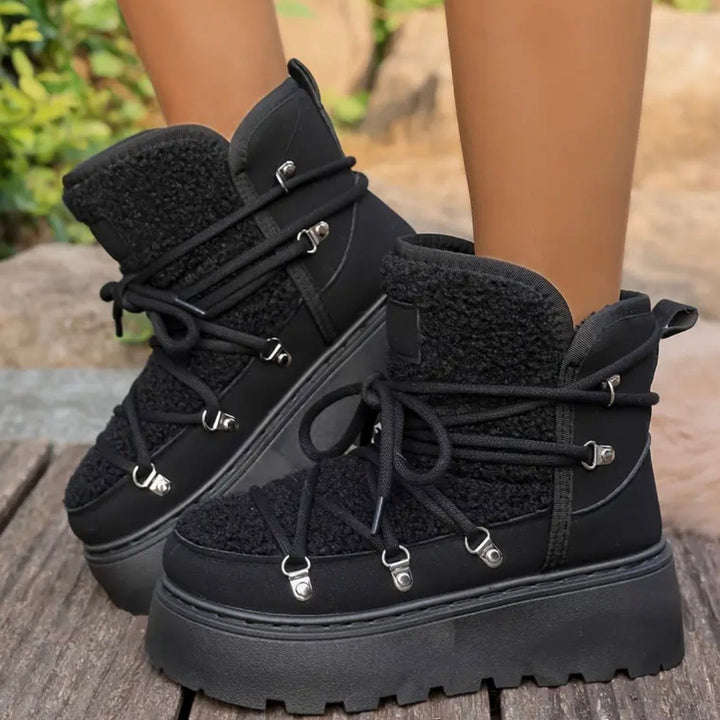 Dettaglio su robusto platform di stivali invernali neri da donna, offre grip e altezza.