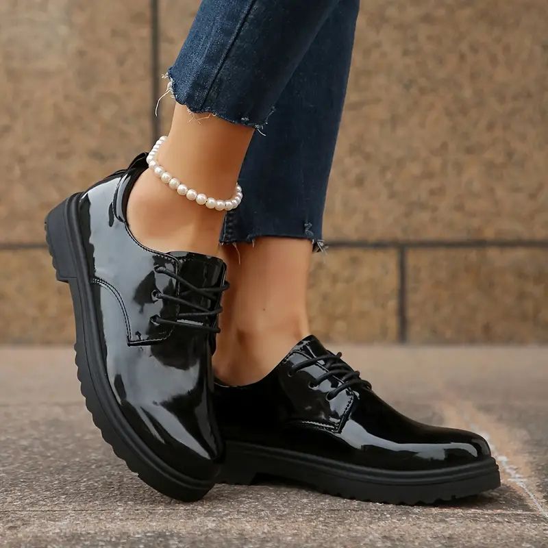 Oxfords da donna nero lucido, scarpe eleganti e comode, perfette per un tocco di stile classico alla moda femminile.
