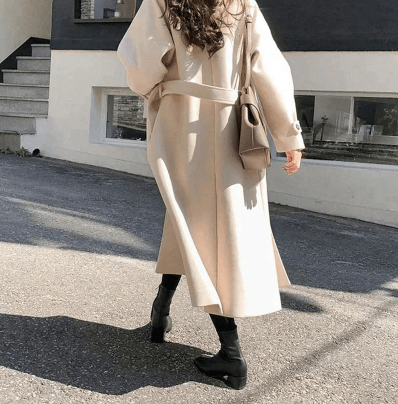Dettaglio di un trench lungo invernale da donna, capo essenziale per un abbigliamento caldo ed elegante.