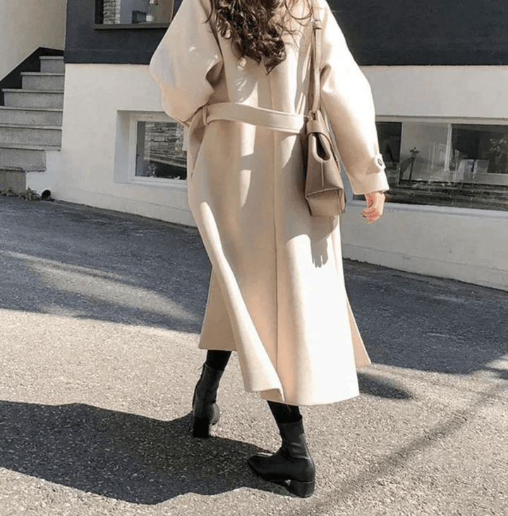 Dettaglio di un trench lungo invernale da donna, capo essenziale per un abbigliamento caldo ed elegante.
