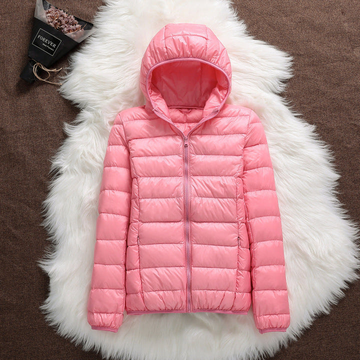 Giacca donna invernale corta con cappuccio, calda e trendy. Piumino aderente per un look moda urban.