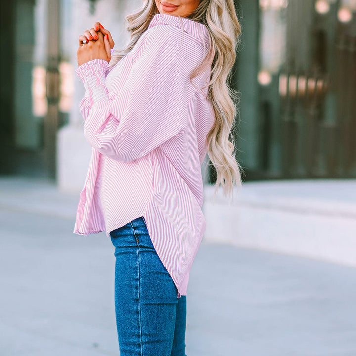 Dettaglio camicia donna a righe, stile oversize abbottonato. Look casual chic con maniche lunghe.