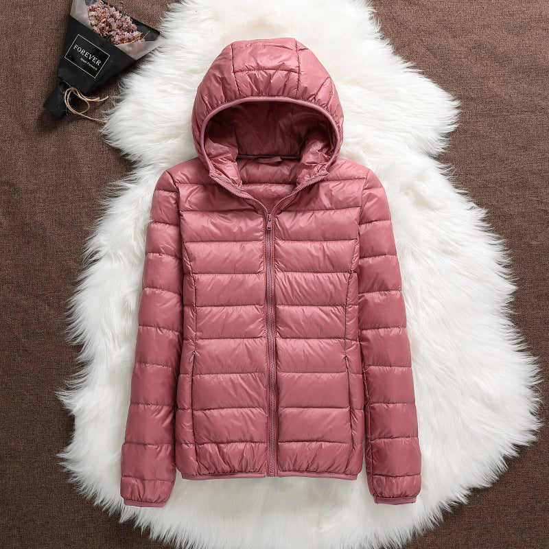 Elegante giacca corta invernale da donna con cappuccio. Caldo piumino per outfit di moda outwear.