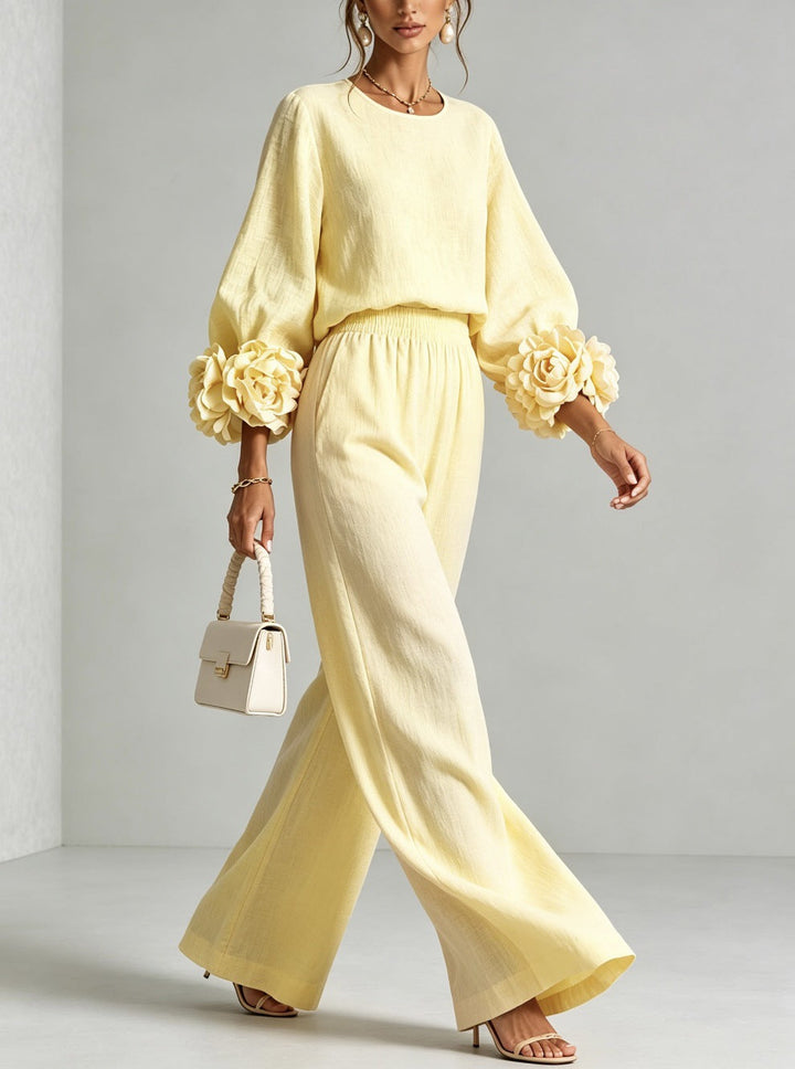 Donna indossa completo floreale elegante, top e pantaloni larghi in lino. Look casual chic e comodo, vita alta.