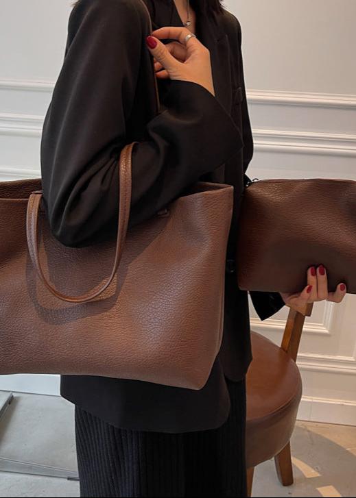 Borsa tote capiente marrone, indossata da donna. Un accessorio versatile che unisce stile e praticità.