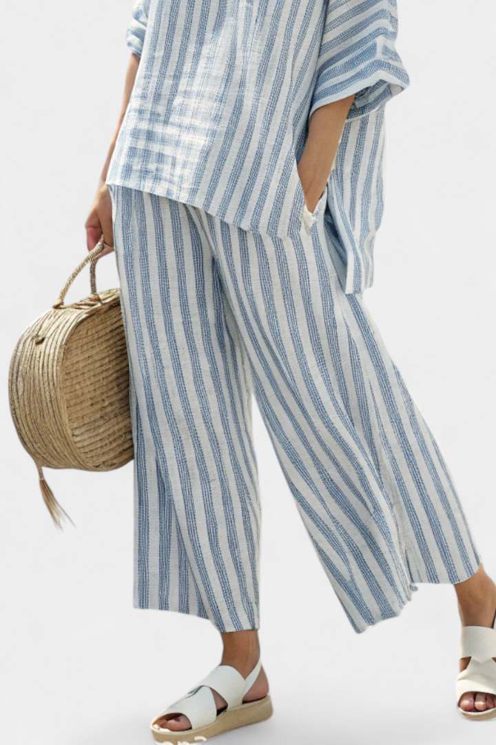 Elegante completo donna a righe blu, con top estivo e pantaloni ampi. Comodo per l'abbigliamento estivo casual.